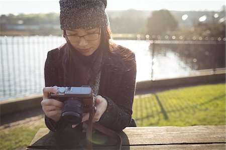 Woman looking at photos on digital camera on a sunny day Stock Photo - Premium Royalty-Free, Code: 6109-08944967