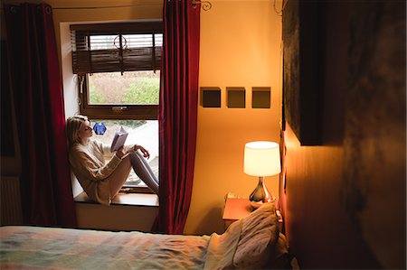 simsearch:6109-07497438,k - Woman sitting on window and reading a book at home Stock Photo - Premium Royalty-Free, Code: 6109-08944988