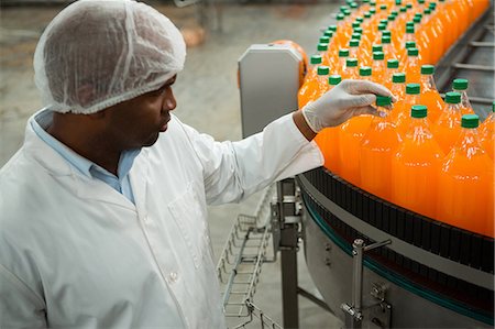 High angle view of serious male worker examining bottles in juice factory Stock Photo - Premium Royalty-Free, Code: 6109-08945071