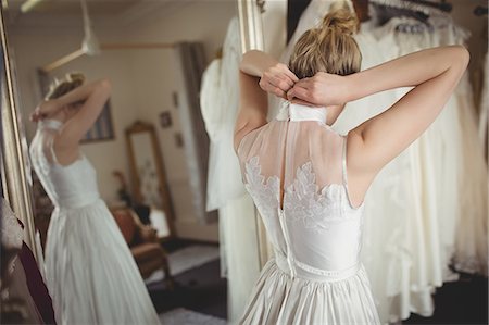 simsearch:700-03696805,k - Rear view of bride wearing wedding dress at boutique Stock Photo - Premium Royalty-Free, Code: 6109-08945257