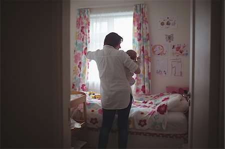 simsearch:6102-08566788,k - Rear view of mother with baby standing by window in bedroom Stock Photo - Premium Royalty-Free, Code: 6109-08945202