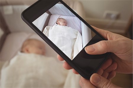 simsearch:6102-08566788,k - Close-up of mother taking picture of sleeping baby through mobile phone Stock Photo - Premium Royalty-Free, Code: 6109-08945224