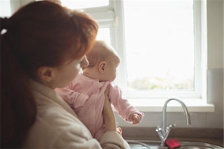 simsearch:6102-08566788,k - Mother and baby looking through kitchen window at home Stock Photo - Premium Royalty-Free, Code: 6109-08945234