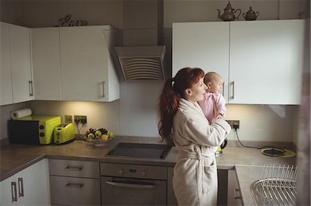 simsearch:6102-08566788,k - Caring mother with baby standing in domestic kitchen Stock Photo - Premium Royalty-Free, Code: 6109-08945235
