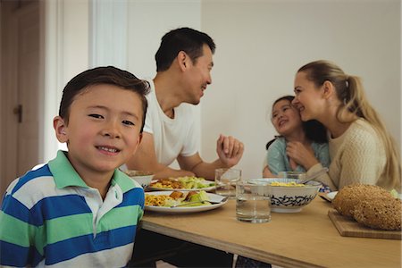 simsearch:400-05119279,k - Portrait of boy smiling while family having meal in background Stock Photo - Premium Royalty-Free, Code: 6109-08953062