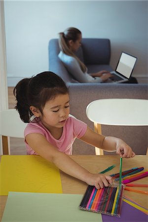simsearch:6109-07497438,k - Girl selecting color pencil while mother using laptop in background Stock Photo - Premium Royalty-Free, Code: 6109-08953074