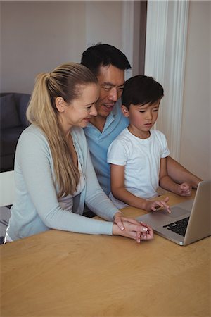 simsearch:400-05354672,k - Family using laptop in living room Stock Photo - Premium Royalty-Free, Code: 6109-08953080