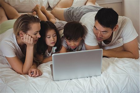 simsearch:400-05119279,k - Happy family using laptop in bedroom Stock Photo - Premium Royalty-Free, Code: 6109-08953088