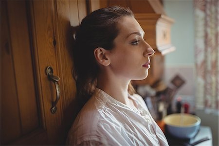 furnished - Thoughtful woman sitting in kitchen Stock Photo - Premium Royalty-Free, Code: 6109-08953304