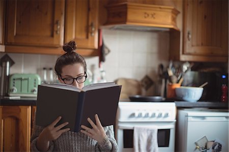 furnished - Woman reading book in kitchen Stock Photo - Premium Royalty-Free, Code: 6109-08953310