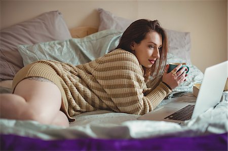 simsearch:693-06120700,k - Woman using laptop while having coffee on bed Stock Photo - Premium Royalty-Free, Code: 6109-08953320