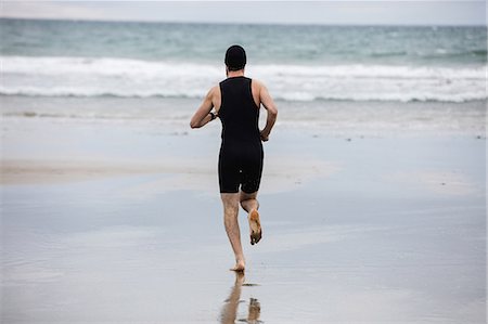 simsearch:6109-06003758,k - Rear view of man in swimming costume and swimming cap running on beach Stock Photo - Premium Royalty-Free, Code: 6109-08928449