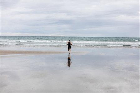 simsearch:628-05817723,k - Rear view of man in swimming costume and swimming cap running on beach Stock Photo - Premium Royalty-Free, Code: 6109-08928450