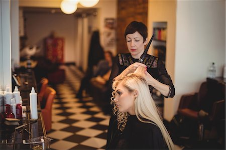 simsearch:693-06022101,k - Female hairdresser styling clients hair in saloon Stock Photo - Premium Royalty-Free, Code: 6109-08928412