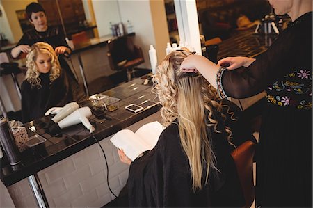 simsearch:693-06022101,k - Female hairdresser styling clients hair in saloon Stock Photo - Premium Royalty-Free, Code: 6109-08928420