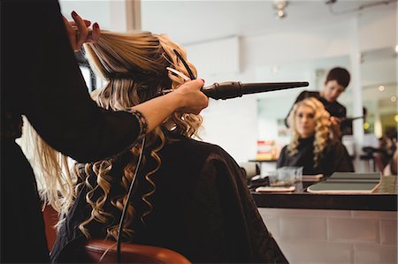 simsearch:693-06022101,k - Female hairdresser styling clients hair in saloon Stock Photo - Premium Royalty-Free, Code: 6109-08928421