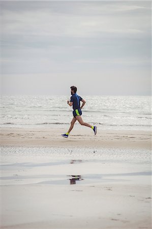 simsearch:6109-06003758,k - Athlete running along the beach on a sunny day Stock Photo - Premium Royalty-Free, Code: 6109-08928515