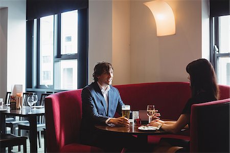 people seating at restaurant - Couple having drinks together in restaurant Stock Photo - Premium Royalty-Free, Code: 6109-08928678