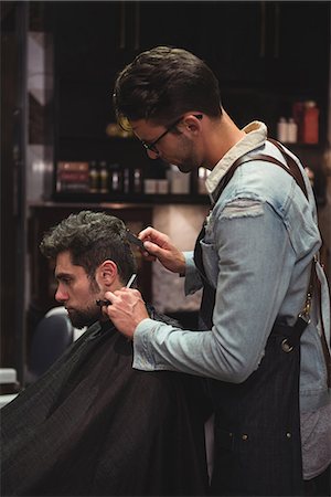 Man getting his hair trimmed with razor in baber shop Stock Photo - Premium Royalty-Free, Code: 6109-08928779