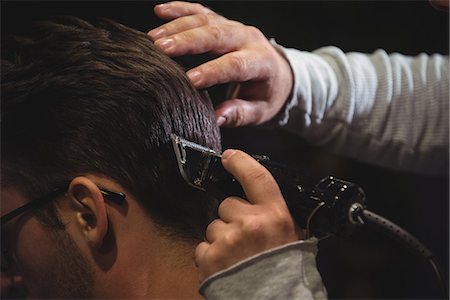 Close-up of man getting his hair trimmed with trimmer in barber shop Photographie de stock - Premium Libres de Droits, Code: 6109-08928806