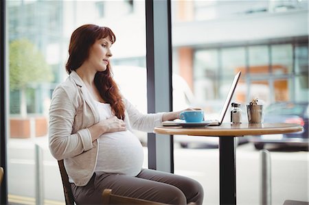 simsearch:6109-08700458,k - Pregnant businesswoman using laptop in office cafeteria Stock Photo - Premium Royalty-Free, Code: 6109-08929287