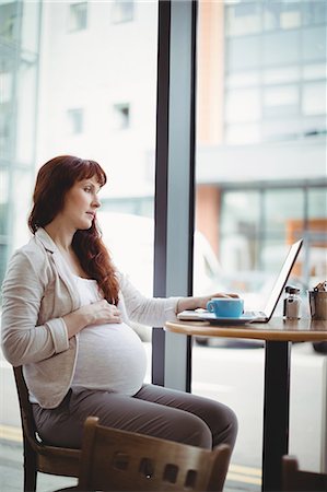 simsearch:6109-08700458,k - Pregnant businesswoman using laptop in office cafeteria Stock Photo - Premium Royalty-Free, Code: 6109-08929288
