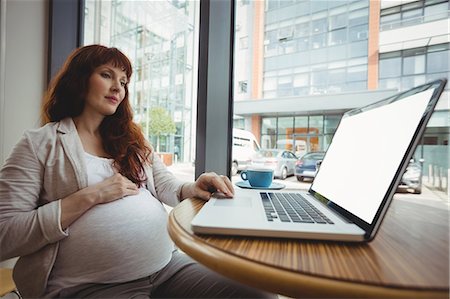 simsearch:6109-08700458,k - Pregnant businesswoman using laptop in office cafeteria Stock Photo - Premium Royalty-Free, Code: 6109-08929296