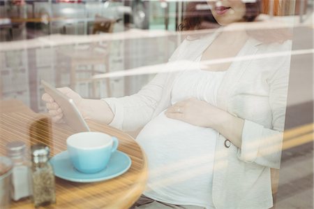 simsearch:6109-08700458,k - Pregnant businesswoman holding digital tablet in office cafeteria Stock Photo - Premium Royalty-Free, Code: 6109-08929299