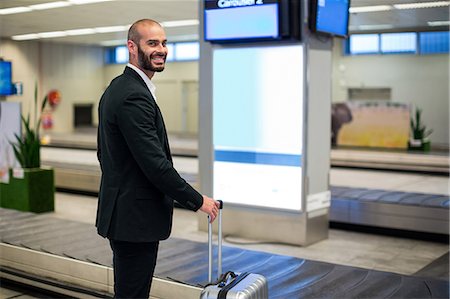 simsearch:400-03938985,k - Portrait of businessman standing with luggage bag in airport Foto de stock - Sin royalties Premium, Código: 6109-08929540