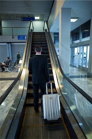 simsearch:400-03938985,k - Rear view of businessman on escalator at airport Foto de stock - Sin royalties Premium, Código: 6109-08929557