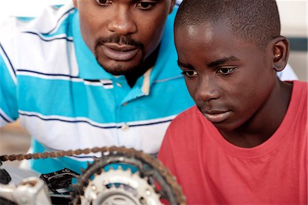 African Father and son working on a bicycle Stock Photo - Premium Royalty-Free, Code: 6110-06702612