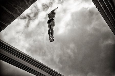 diving (not water) - Man on the upwards jump of a high dive Stock Photo - Premium Royalty-Free, Code: 6110-09101684