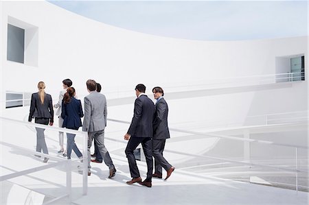 Business people walking up elevated walkway Stock Photo - Premium Royalty-Free, Code: 6113-06497895