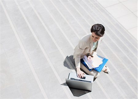 steps high angle - Businesswoman with paperwork using laptop on urban steps Stock Photo - Premium Royalty-Free, Code: 6113-06497803