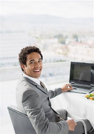Portrait of smiling businessman using laptop in office Stock Photo - Premium Royalty-Free, Code: 6113-06497812