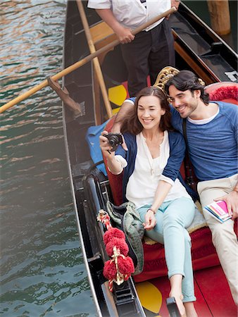 simsearch:6113-06498180,k - Smiling couple taking photographs in gondola on canal in Venice Stock Photo - Premium Royalty-Free, Code: 6113-06498136