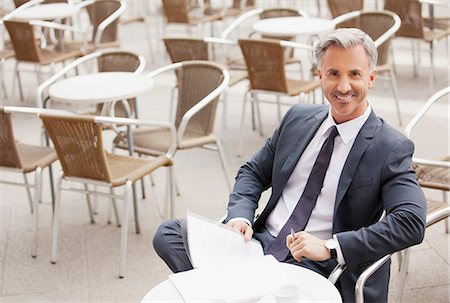 sidewalk cafe - Portrait of smiling businessman with paperwork at sidewalk cafe Stock Photo - Premium Royalty-Free, Code: 6113-06498279