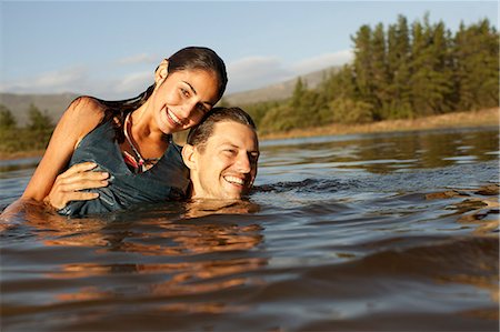 Portrait of smiling couple swimming in lake Stock Photo - Premium Royalty-Free, Code: 6113-06498522