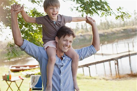 simsearch:6113-06899473,k - Father carrying smiling son on shoulders at lakeside Stock Photo - Premium Royalty-Free, Code: 6113-06498528