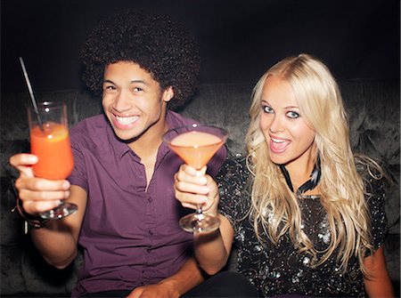 simsearch:6113-07543030,k - Portrait of enthusiastic couple toasting cocktails in nightclub Stock Photo - Premium Royalty-Free, Code: 6113-06498651