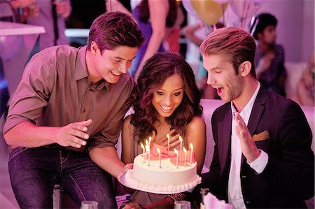 Friends with birthday cake in nightclub Stock Photo - Premium Royalty-Free, Code: 6113-06498605
