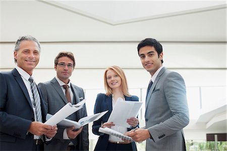 Portrait of smiling business people reviewing paperwork Stock Photo - Premium Royalty-Free, Code: 6113-06498766