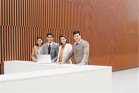 simsearch:6113-07243187,k - Portrait of confident business people with laptop at ledge in office Stock Photo - Premium Royalty-Free, Code: 6113-06498788
