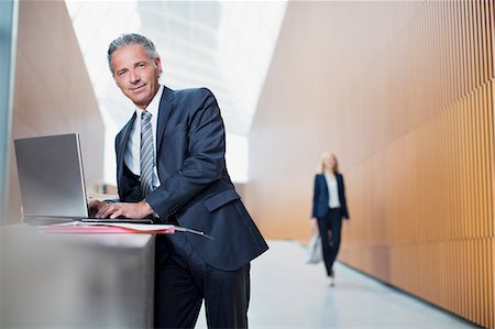 Portrait of confident businessman using laptop in office Stock Photo - Premium Royalty-Free, Code: 6113-06498790