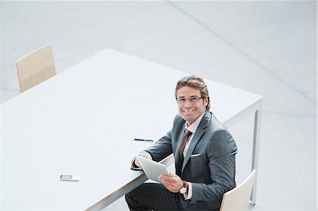 simsearch:6113-07243187,k - Portrait of confident businessman with digital tablet at table Stock Photo - Premium Royalty-Free, Code: 6113-06498802