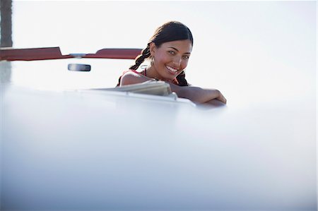 Smiling woman leaning out of convertible Stock Photo - Premium Royalty-Free, Code: 6113-06498952