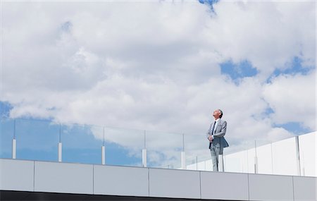 determined - Pensive businessman looking up at sky on rooftop balcony Stock Photo - Premium Royalty-Free, Code: 6113-06498906