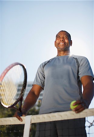 Older man playing tennis on court Stock Photo - Premium Royalty-Free, Code: 6113-06499044