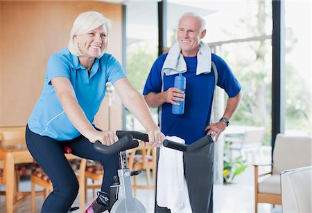 fitness man exhausting - Older woman riding exercise bike at home Stock Photo - Premium Royalty-Free, Code: 6113-06499045