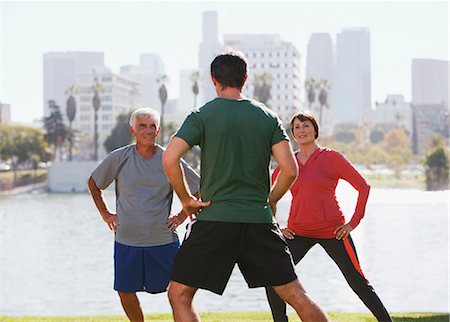 simsearch:6113-06498180,k - Older couple exercising with trainer in park Stock Photo - Premium Royalty-Free, Code: 6113-06499077